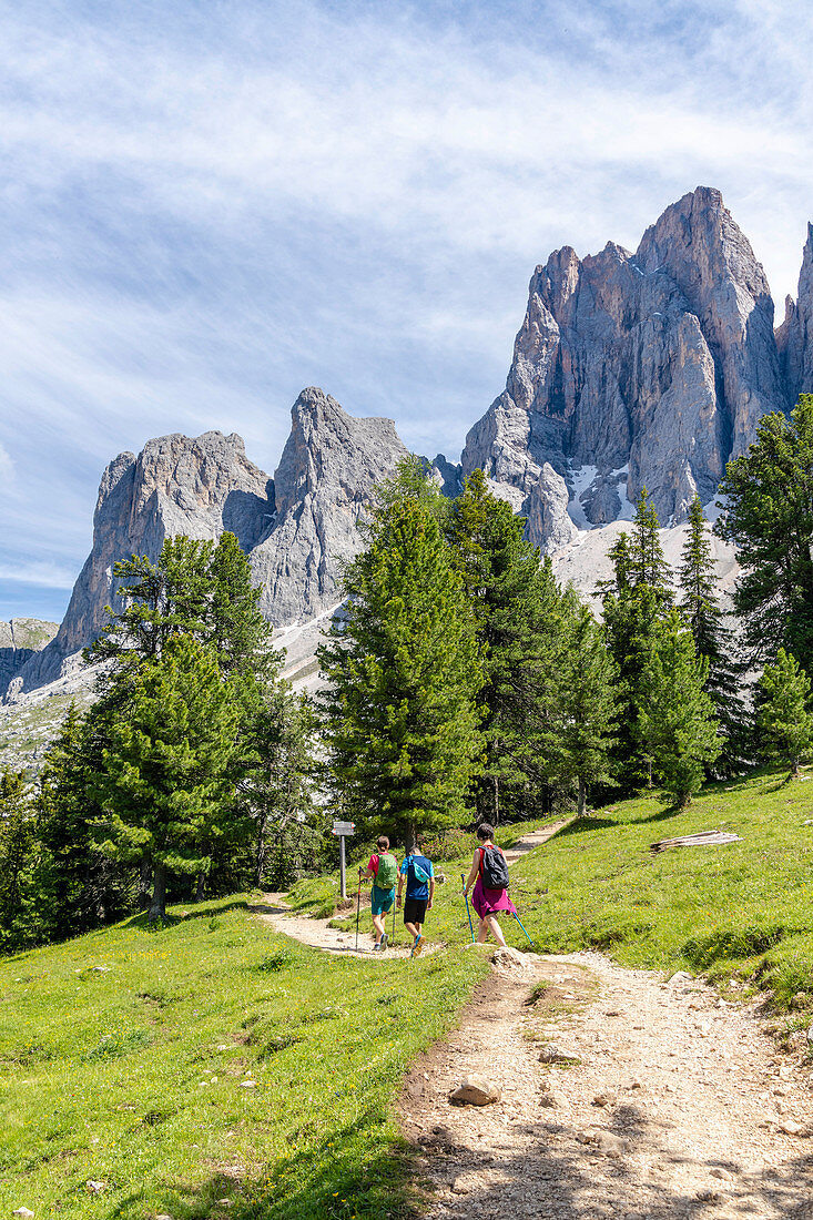 Wanderer, die auf dem Adolf Munkel Weg am Fuße der Odle, Val di Funes, Südtirol, Dolomiten, Italien, Europa gehen