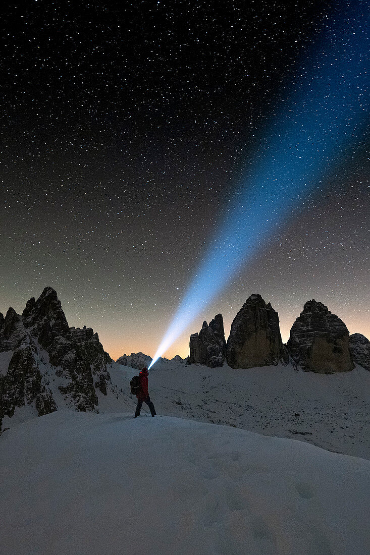 Wanderer mit Stirnlampe bewundern Sterne auf Monte Paterno und Tre Cime di Lavaredo, Sesto Dolomiten, Südtirol, Italien, Europa