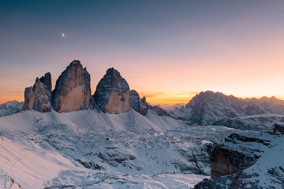 Sonnenuntergang über Tre Cime di Lavaredo und Monte Cristallo bedeckt mit Schnee im Herbst, Dolomiten, Grenze von Südtirol und Venetien, Italien, Europa