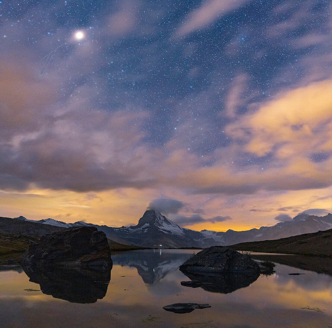 Matterhorngipfel beleuchtet durch Mond im sternenklaren Nachthimmel gesehen von Stellisee, Zermatt, Walliser Kanton, Schweiz, Europa