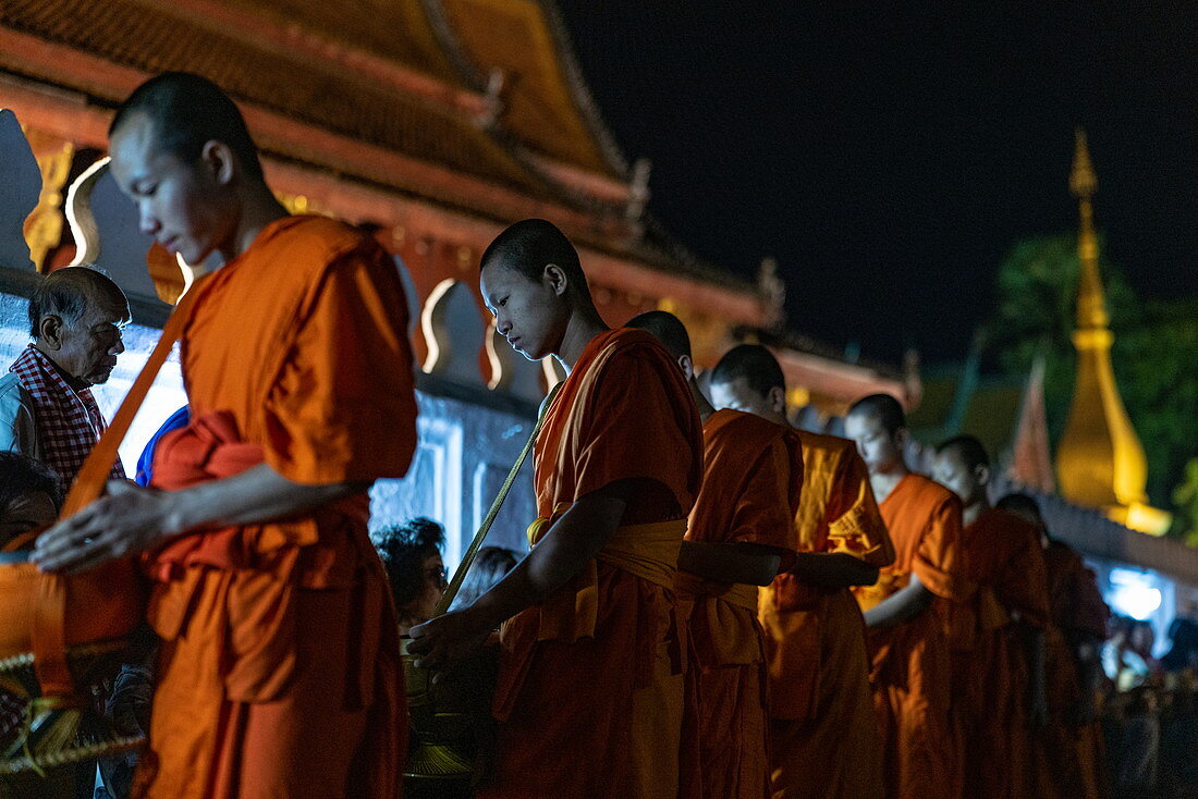 Barfuß laufende Mönche sammeln am frühen Morgen Essen und Trinken Almosen (Sai Bat), Luang Prabang, Provinz Luang Prabang, Laos, Asien