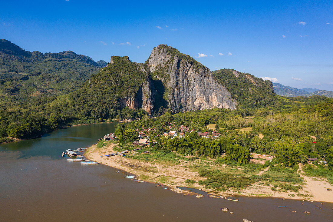 Luftaufnahme vom Dorf Pak Ou entlang vom Fluss Mekong mit Bergen dahinter, Chomphet Bezirk, Luang Prabang Provinz, Laos, Asien