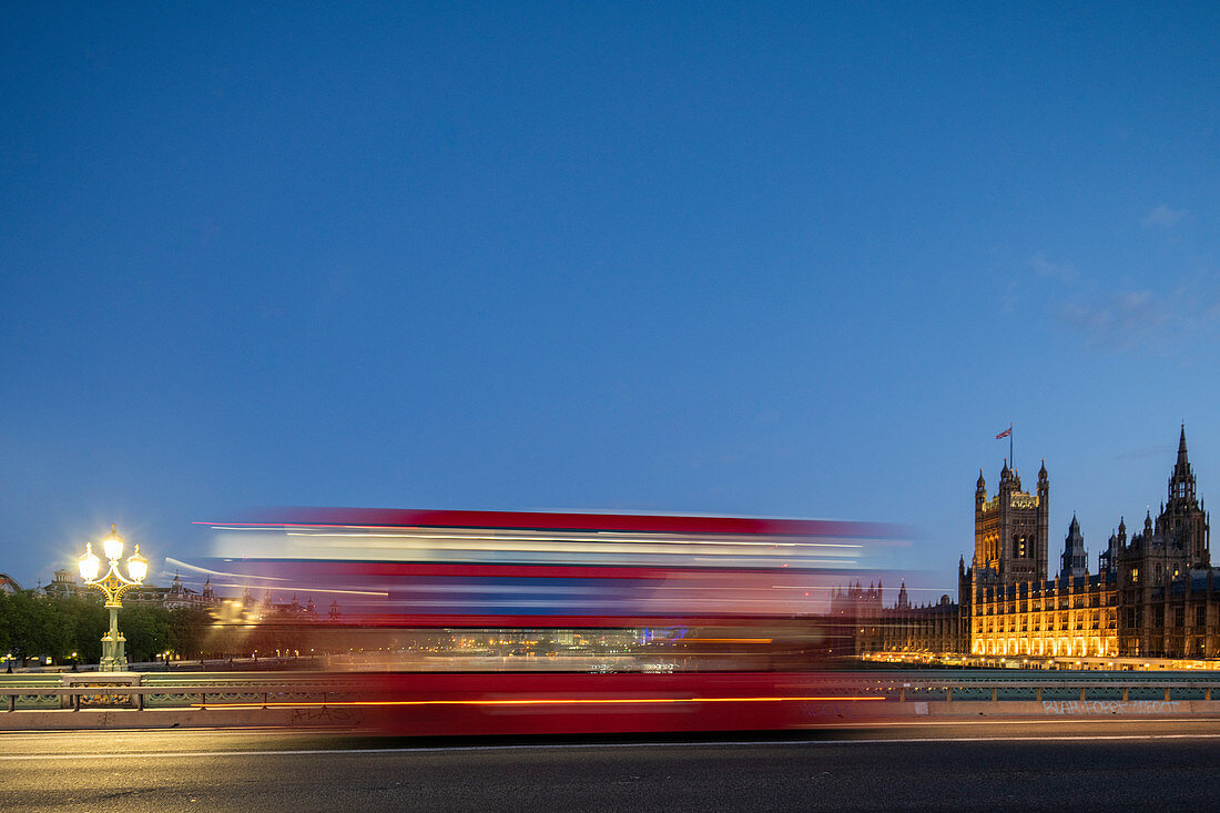 Ein roter Londoner Bus fährt verschwommen über die Westminster Bridge, London, England, Großbritannien, Europa