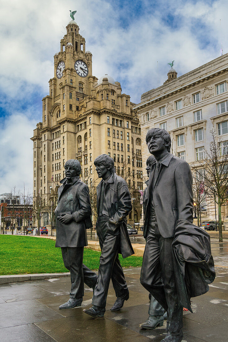 The Beatles statue, bronze art depicting the famous band facing river Mersey with Royal Liver Building in the background, Liverpool, Merseyside, England, United Kingdom, Europe