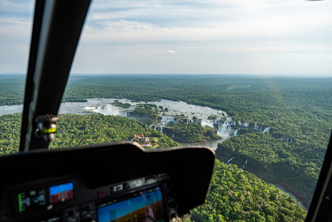 Aerial view of the waterfalls at Iguazu Falls seen through the window of a helicopter with cockpit instruments in the foreground, Iguazu National Park, Parana, Brazil, South America