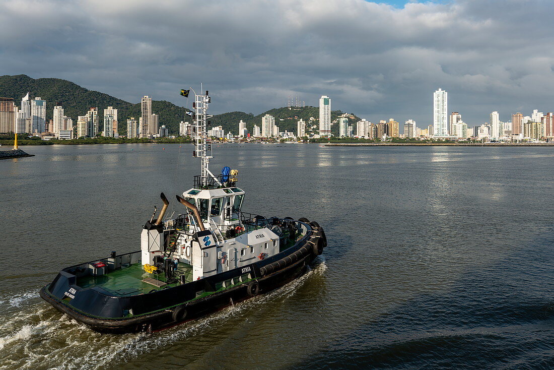 Schlepper mit Skyline der Stadt dahinter, Itajai, Santa Catarina, Brasilien, Südamerika