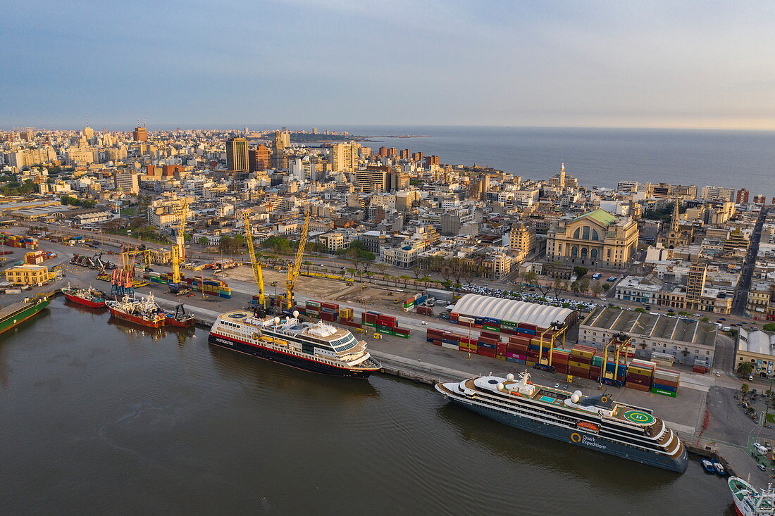 Aerial view of expedition cruise ships Midnatsol (Hurtigruten Cruises) and World Explorer (nicko cruises) with city skyline behind at sunrise, Punta del Este, Maldonado Department, Uruguay, South America