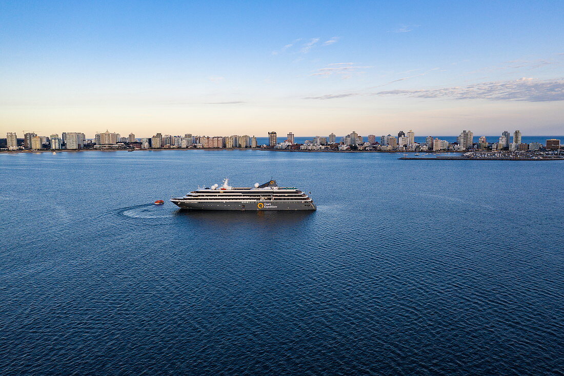 Aerial view of expedition cruise ship World Explorer (Nicko Cruises) with city skyline behind at sunset, Punta del Este, Maldonado Department, Uruguay, South America