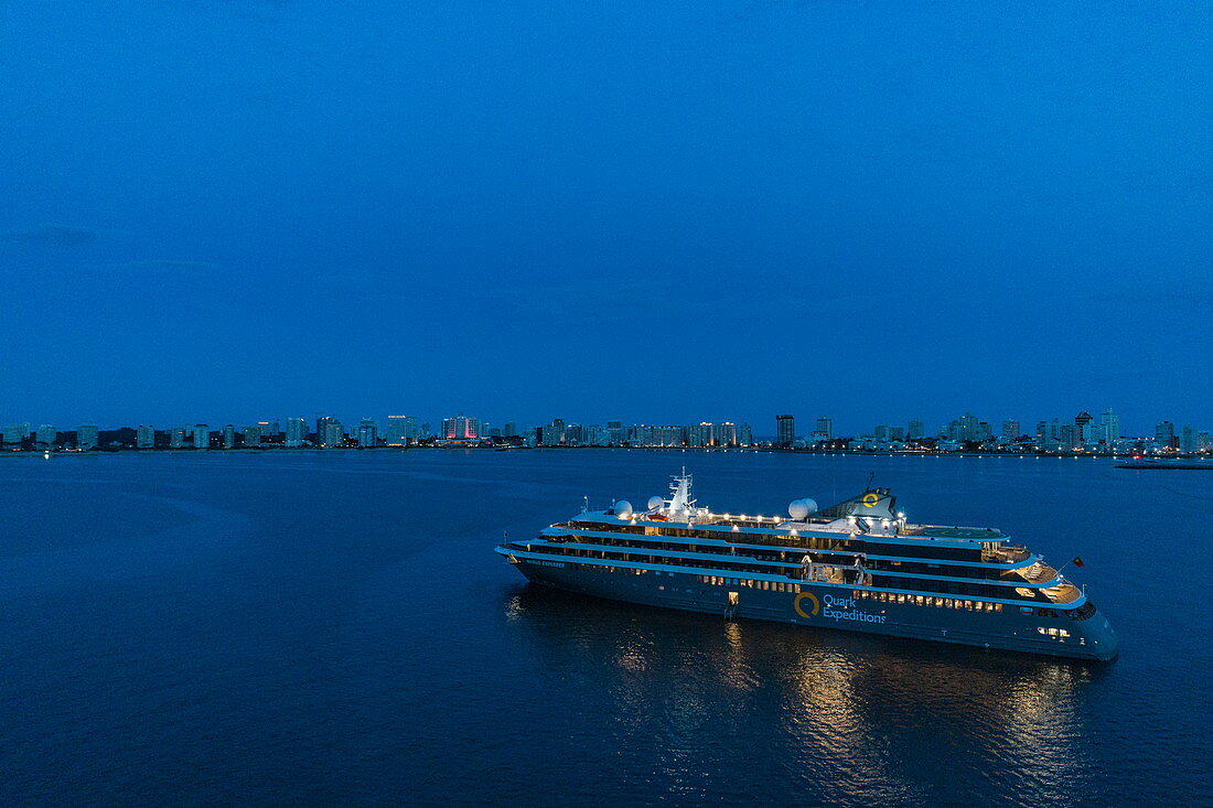 Luftaufnahme von Expeditions Kreuzfahrtschiff World Explorer (nicko cruises) mit Skyline der Stadt dahinter in der Abenddämmerung, Punta del Este, Maldonado Department, Uruguay, Südamerika