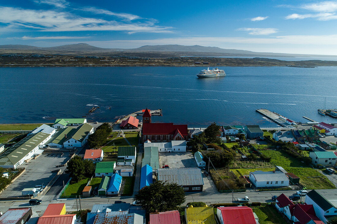 Luftaufnahme von Stadtzentrum mit Expeditions Kreuzfahrtschiff World Explorer (nicko cruises) dahinter, Stanley, Falklandinseln, Britisches Überseegebiet, Südamerika