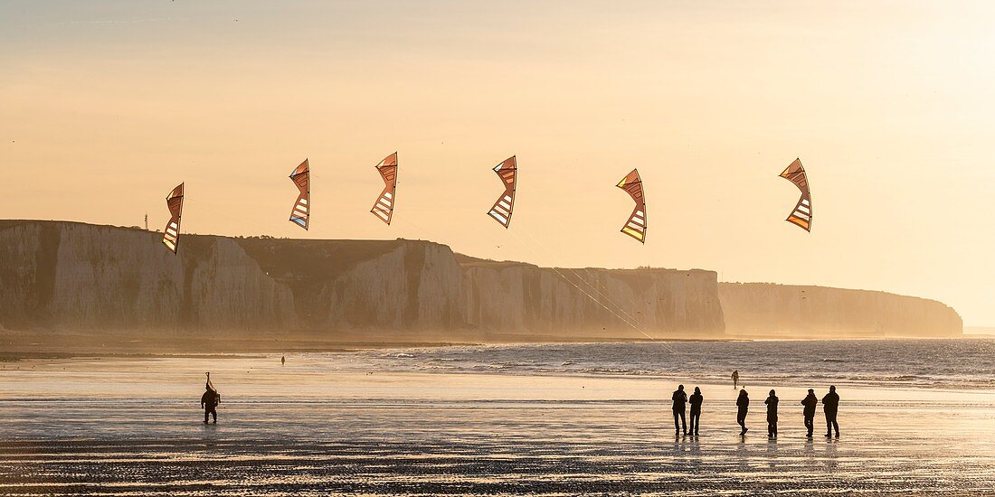 Frankreich, Somme, Ault, Team von Cervicists, die synchronisiertes Drachenfliegen am Strand von Ault in der Nähe der Klippen bei Sonnenuntergang trainiert