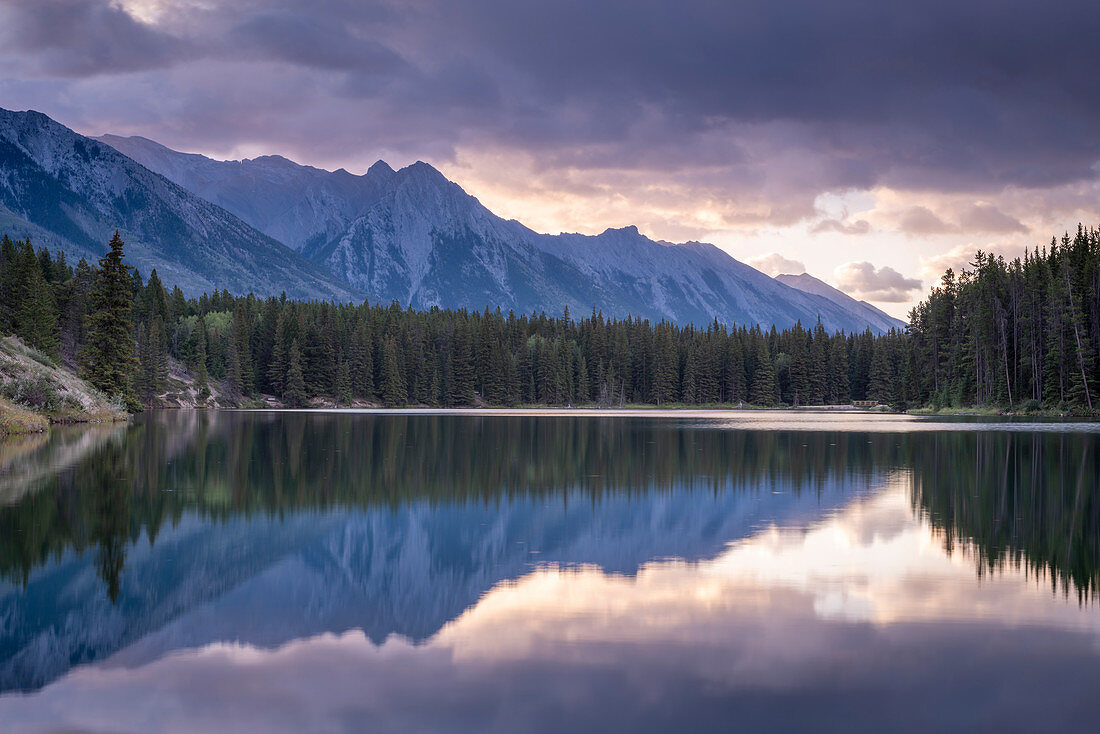 Sonnenaufgang über den Bergen der Rocky Mountains, reflektiert in Johnson Lake, Banff National Park, UNESCO-Weltkulturerbe, Alberta, Kanada, Nordamerika
