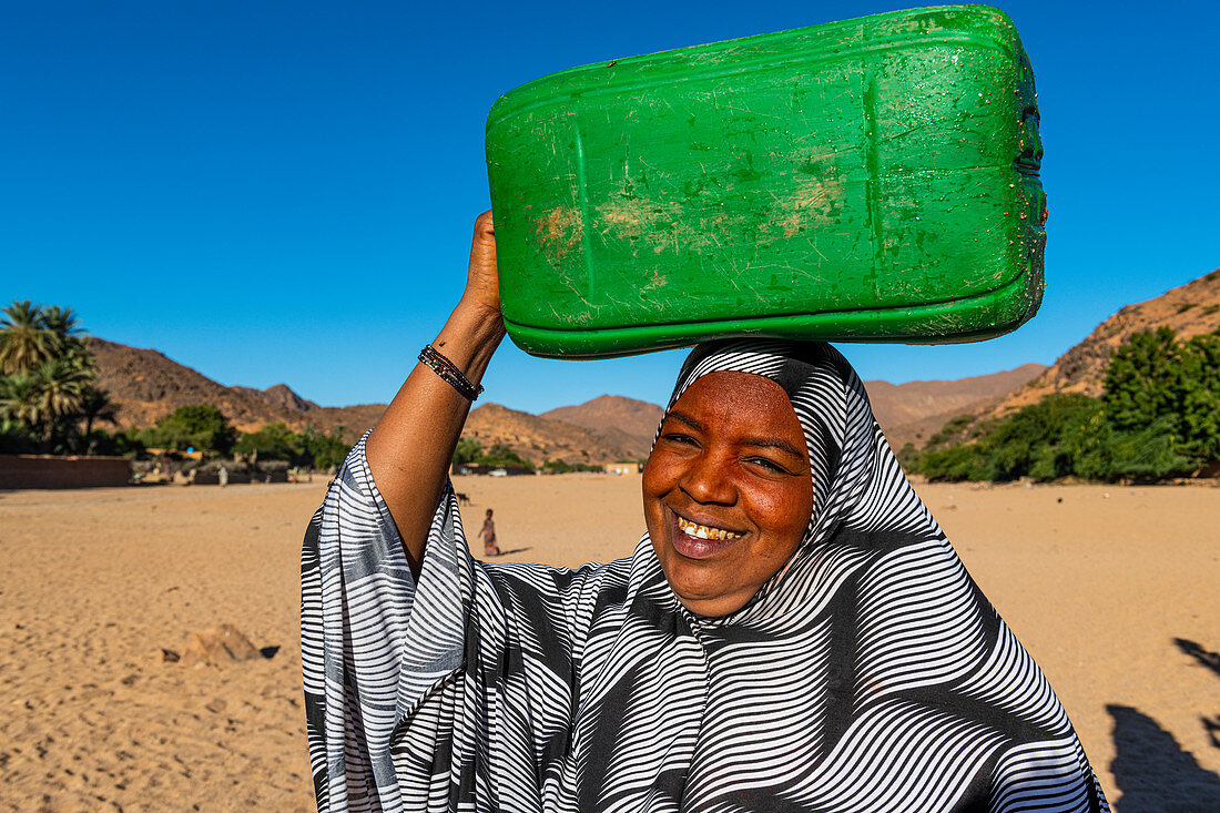 Frau, die einen Wasserbehälter auf ihrem Kopf, Oase von Timia, Luftberge, Niger, Afrika trägt