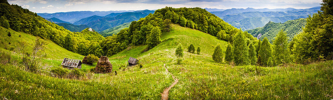 Ländliche Landschaft mit traditionellen strohgedeckten Holzhäusern in Dumesti, Apuseni-Gebirge, Rumänien, Europa