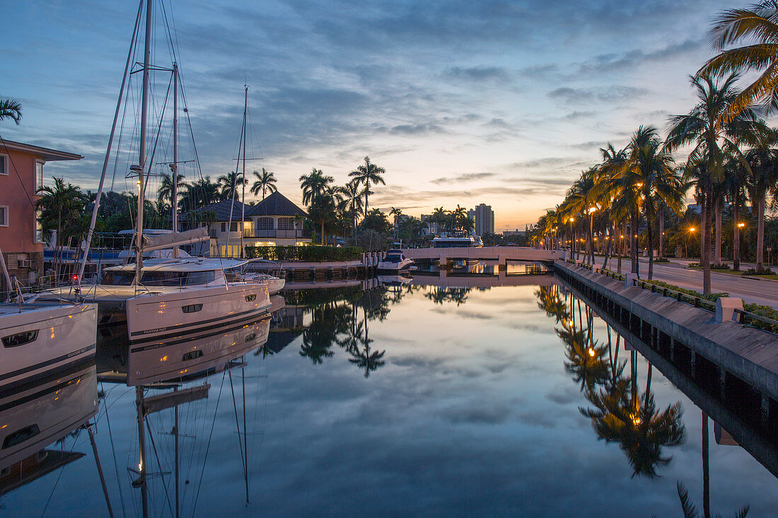 Blick entlang des ruhigen Kanals im Morgengrauen, Yachten, die sich im stillen Wasser spiegeln, Nurmi-Inseln, Fort Lauderdale, Florida, Vereinigte Staaten von Amerika, Nordamerika