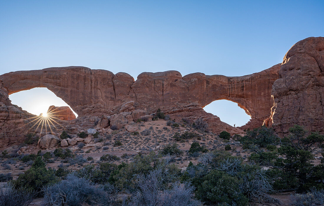 Sunburst und Wanderer in Windows Arches, Arches National Park, Utah, Vereinigte Staaten von Amerika, Nordamerika