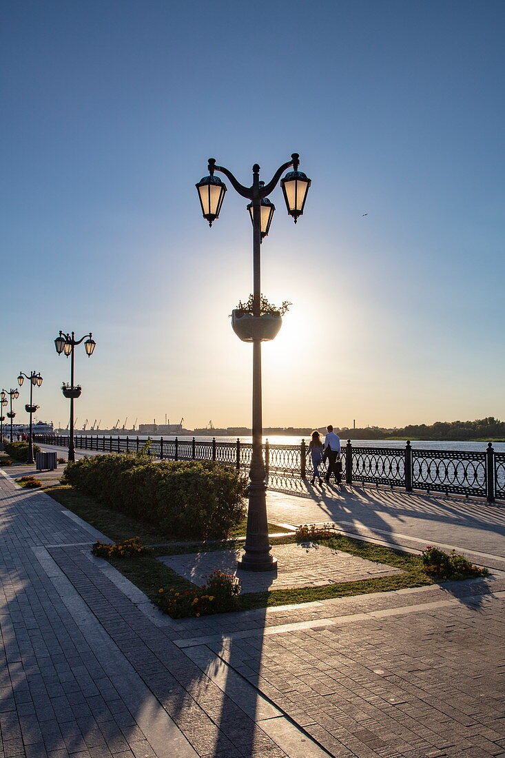 Silhouette von Straßenlaternen und Menschen die entlang Promenade am Ufer von Fluss Wolga spazieren, Astrachan, Bezirk Astrachan, Russland, Europa