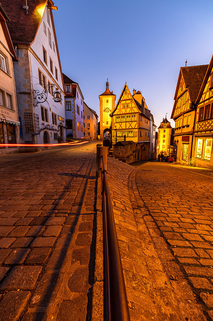 Berühmte Gabelung "Plönlein" zur blauen Stunde mit Lichtstreifen von Auto in Rothenburg ob der Tauber, Mittelfranken, Bayern, Deutschland