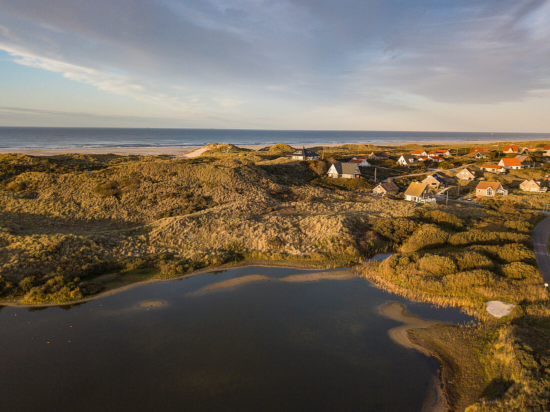 Aerial view of holiday homes by a lake and in the midst of dunes along the North Sea coast at sunset, Midsland aan Zee, Terschelling, West Frisian Islands, Friesland, Netherlands, Europe