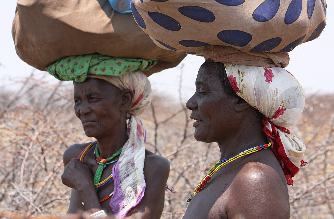 Angola; westlicher Teil der Provinz Cunene; zwei Frauen am Straßenrand; ihr Gepäck auf dem Kopf tragend