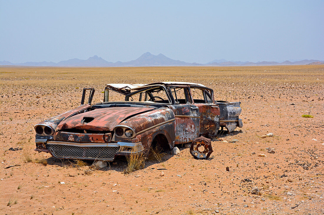 Angola; in the southern part of Namibe Province; Desert in Iona National Park; End of dry season; Gravel plain and extensive grassy areas; Wreck of a vintage car; Spare parts were cannibalized