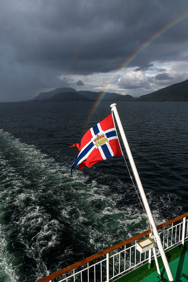 View from the Hurtigruten ship Richard With with the Norwegian flag between Bronnoysund and Rorvik, Norway