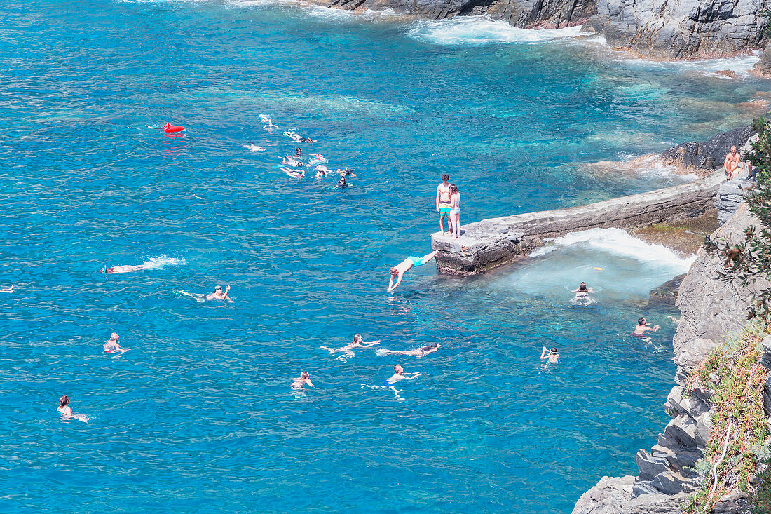 Holiday makers swimming, Manarola, Cinque Terre, Liguria, Italy