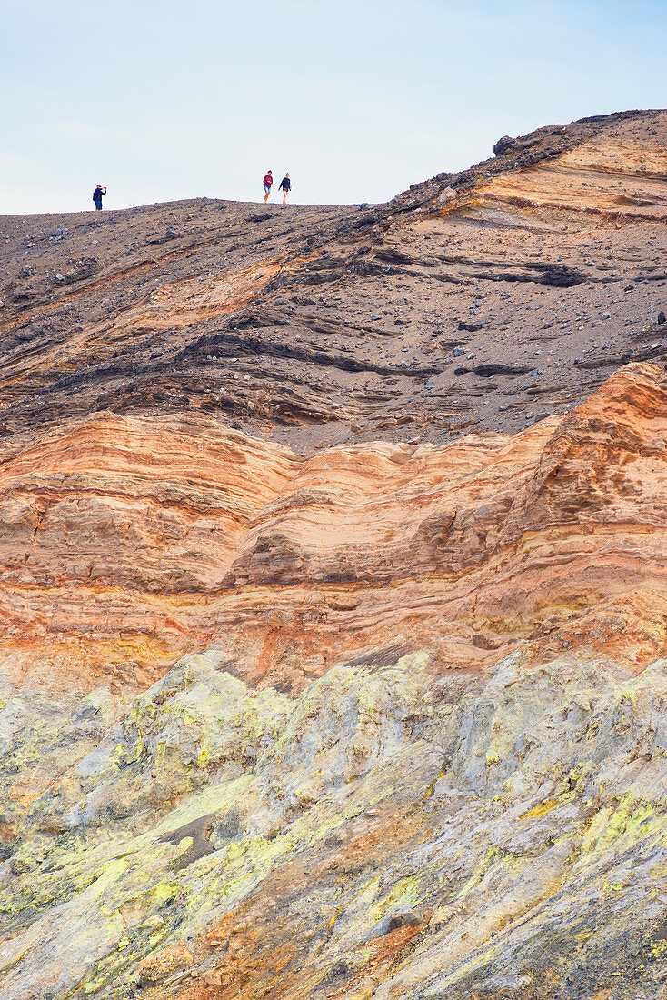 Hikers walking around Gran Crater rim, Vulcano Island, Aeolian Islands, Sicily, Italy