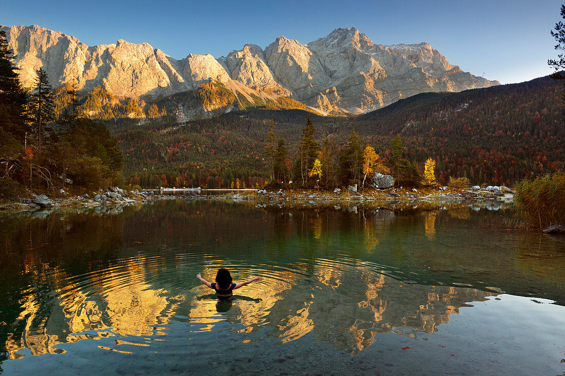 Woman bathing, autumn at the Eibsee, view to the Zugspitze, Werdenfelser Land, Bavaria, Germany