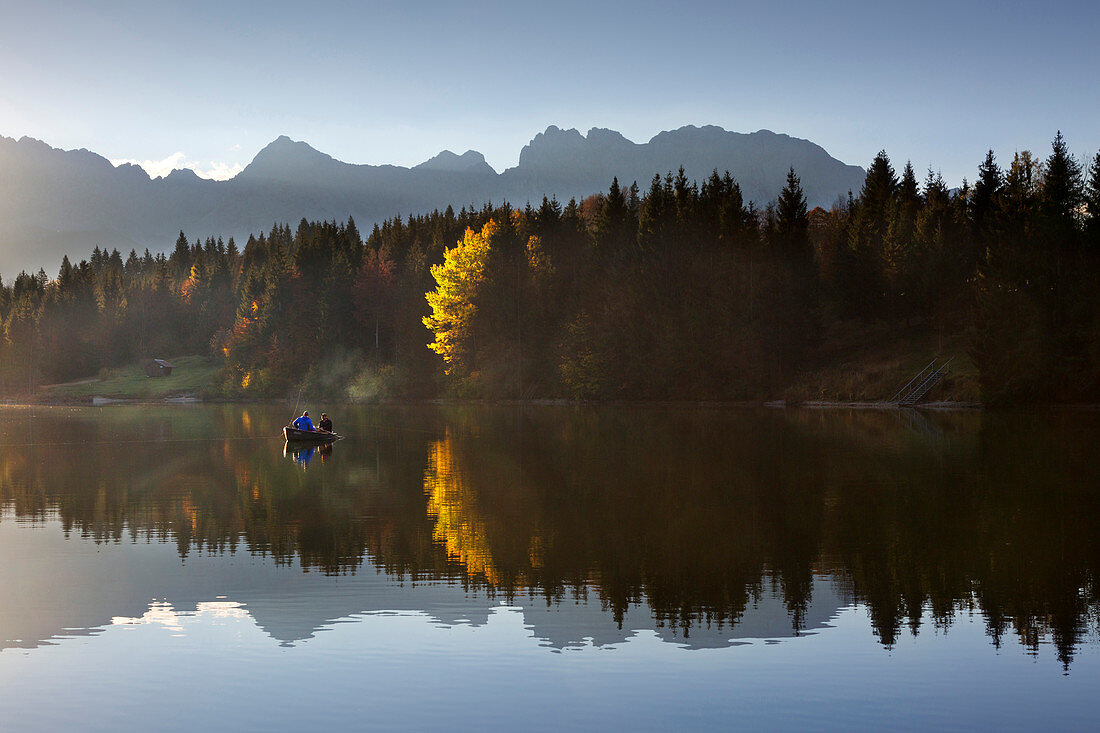 Angler im Ruderboot auf dem Geroldsee im Herbst, Blick zum Karwendel, Werdenfelser Land, Bayern, Deutschland