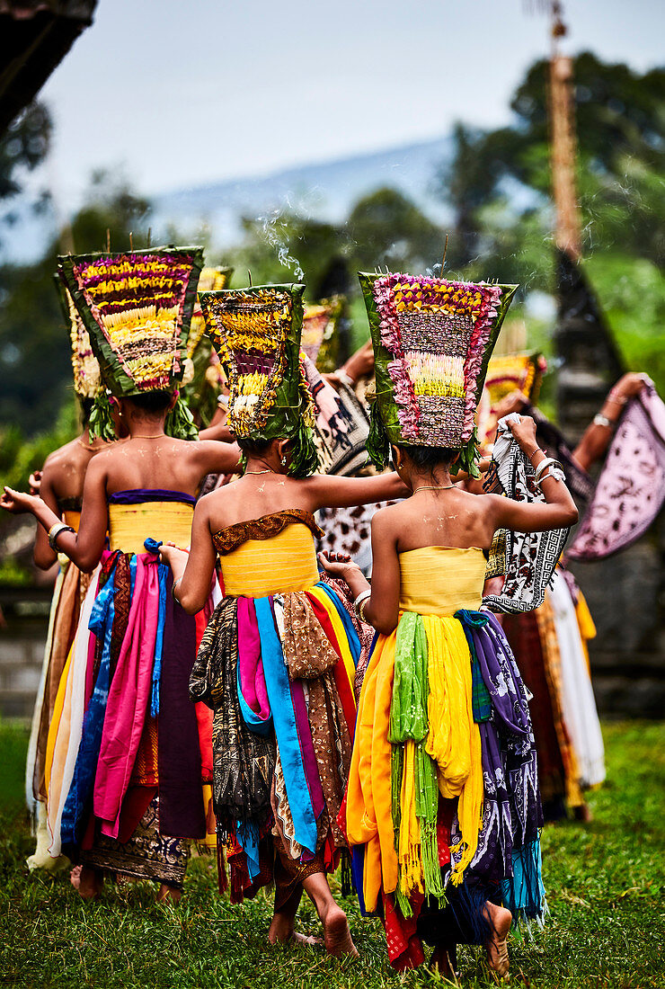 Adolescent Balinese girls dancing in temple grounds during the festival of Galungan and Kuningan, Karangasem, Bali, Indonesia