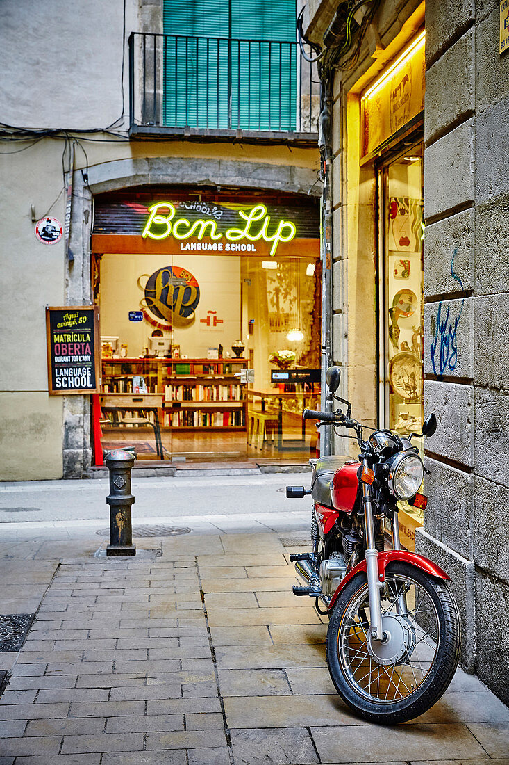 Ein rotes Motorrad geparkt in einer Seitenstraße des gotischen Viertels von Barcelona, Katalonien, Spanien