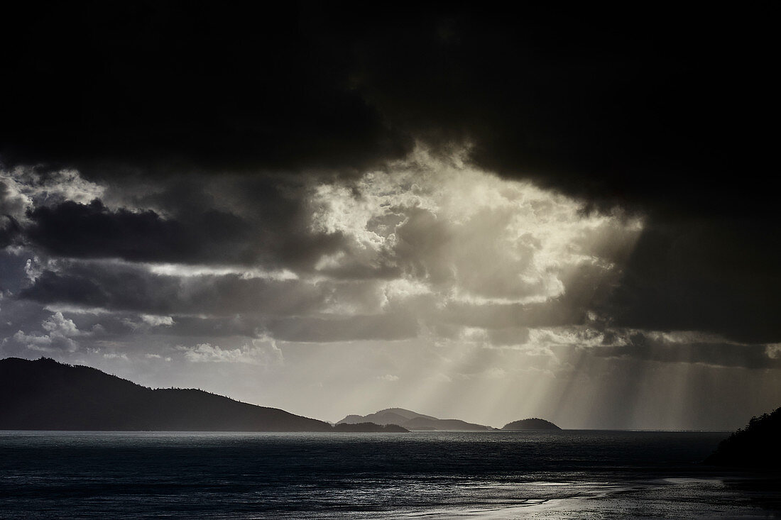 Regenwolken überrollen einen Sonnenaufgang auf Hamilton Island, Whitsunday Islands, Queensland, Australien