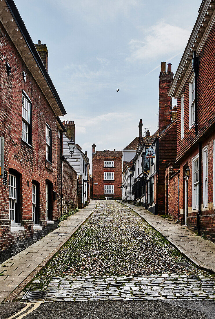 Straßenbild einer Gasse mit Wohnhäusern und Geschäften in Rye, East Sussex, UK