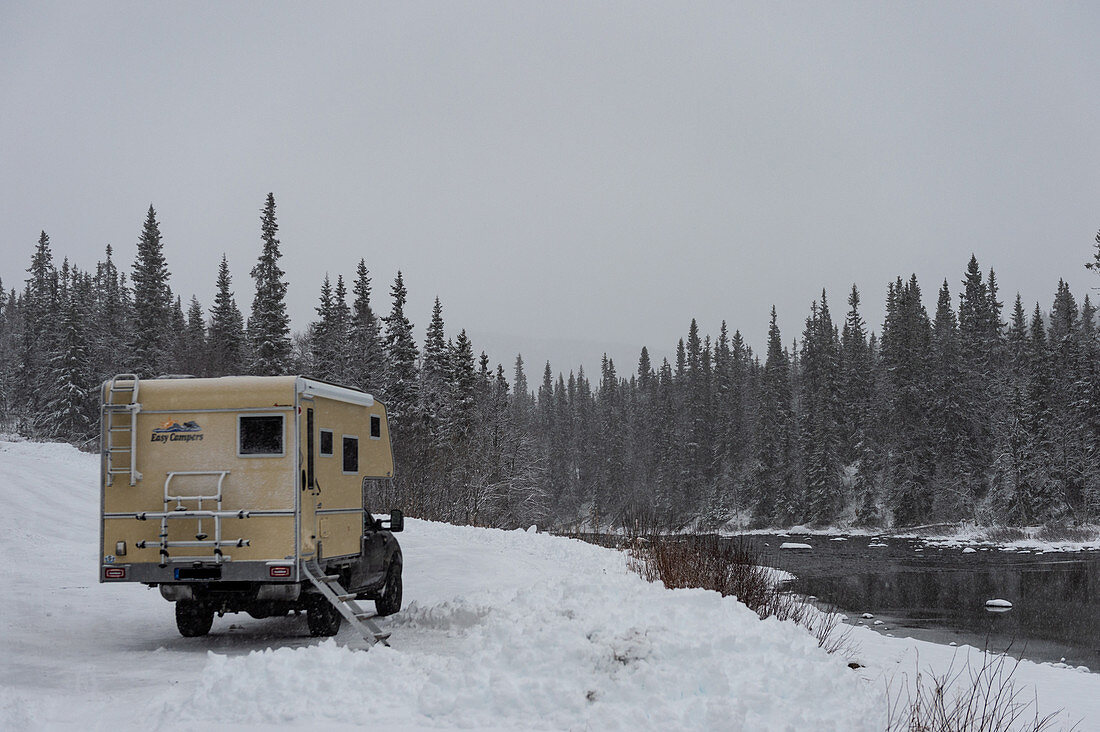 Ford Ranger mit Aufsetzkabine im tiefen Schnee an einem Fluss, Storjola, Lappland, Schweden