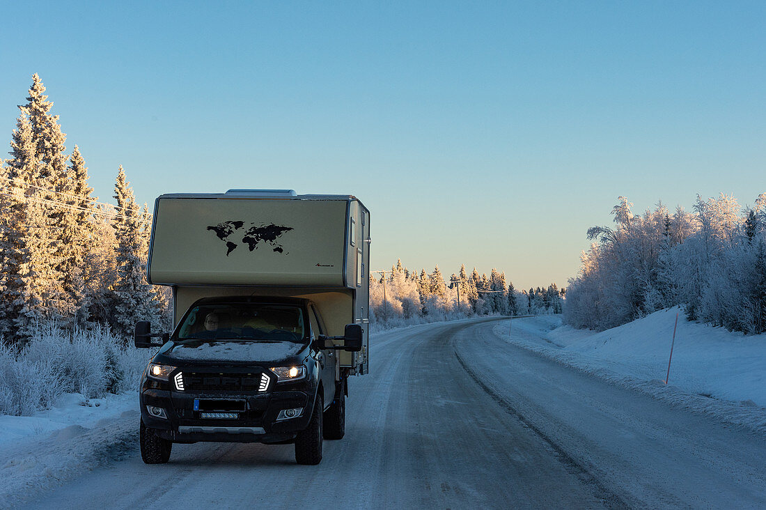Ford Ranger mit Aufsetzkabine auf eisiger Strasse im tiefen Winter, bei Lycksele, Lappland, Schweden