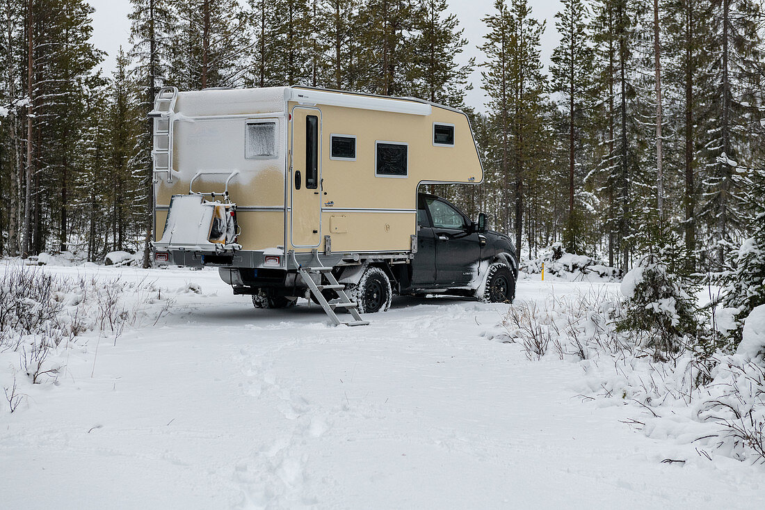 Van in deep snow in winter forest in Lapland, Arvidsjaur, Sweden