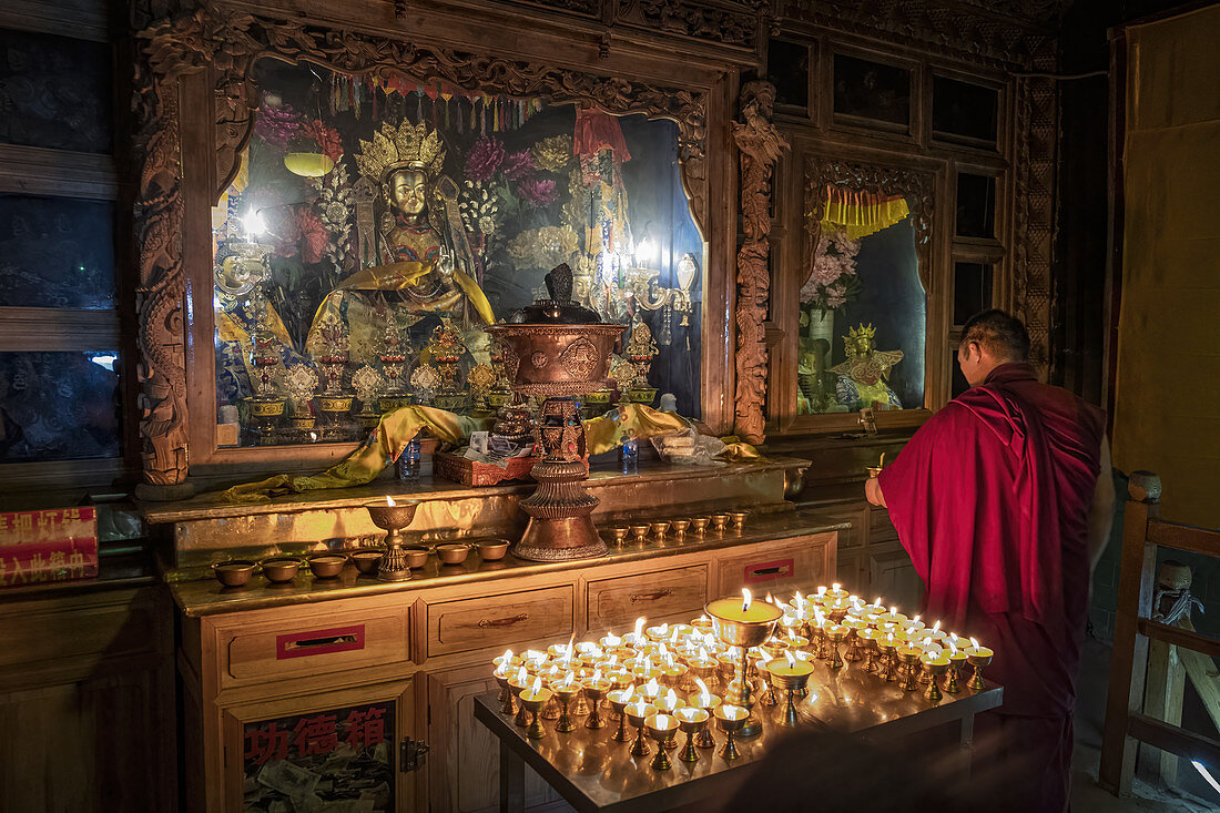 Ein buddhistischer Mönch, der im Bati-Tempel, Gansu, China, Asien betet