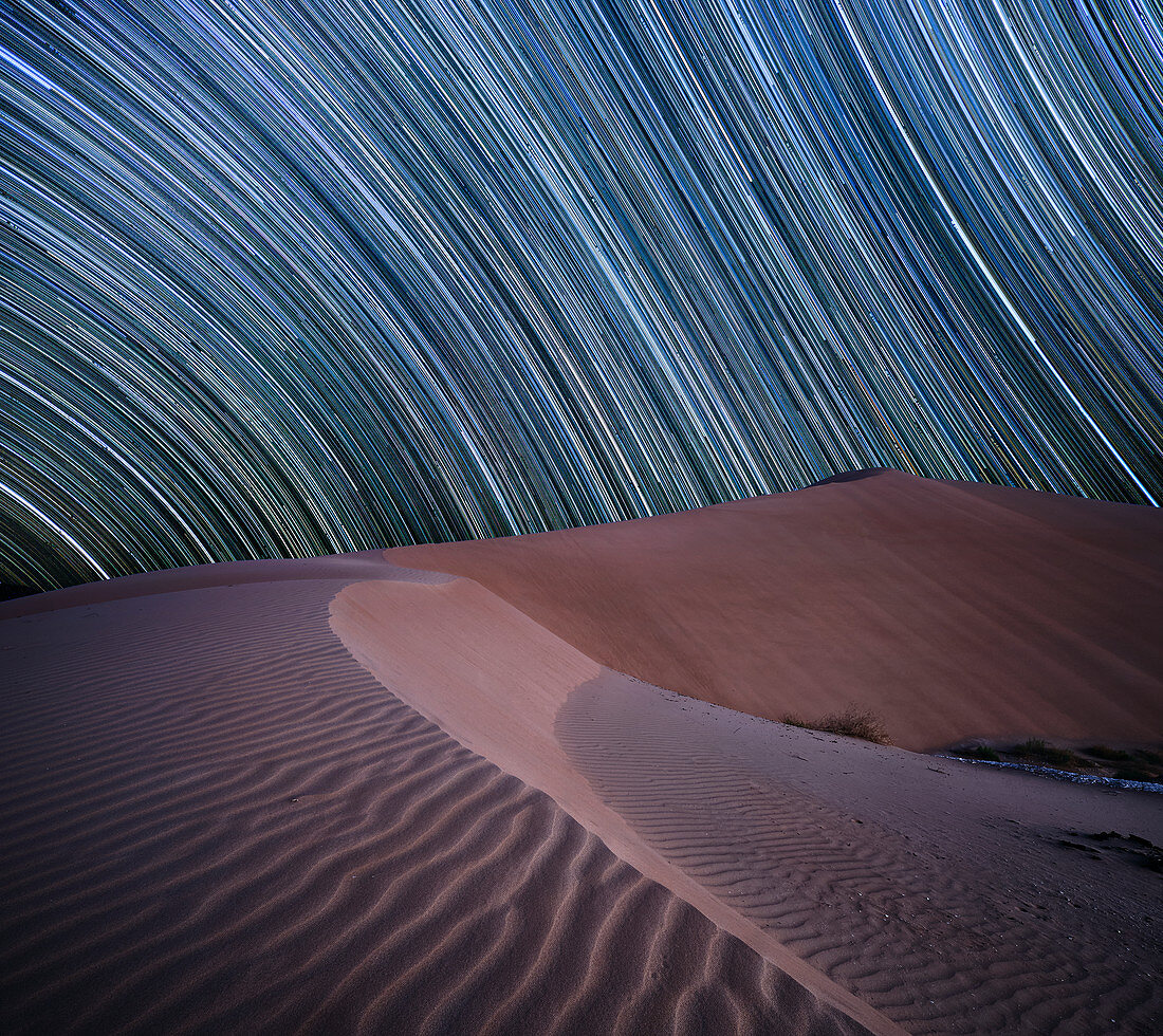 Equatorial star trail above sand dunes in the Rub al Khali desert, Oman, Middle East