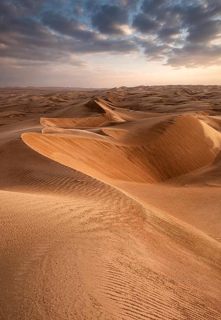 Sanddünen bei Sonnenuntergang in der Wahiba Sands Wüste mit Wolken im Himmel, Oman, Naher Osten