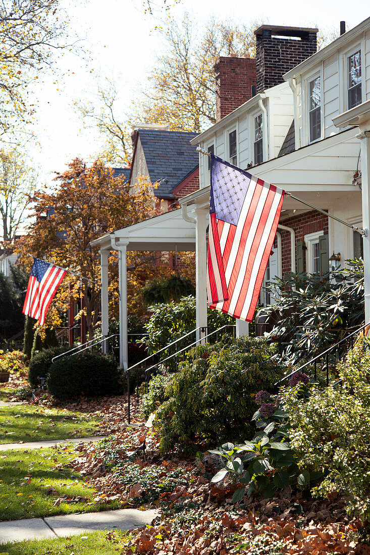 American flags hanging in front of Suburban Houses