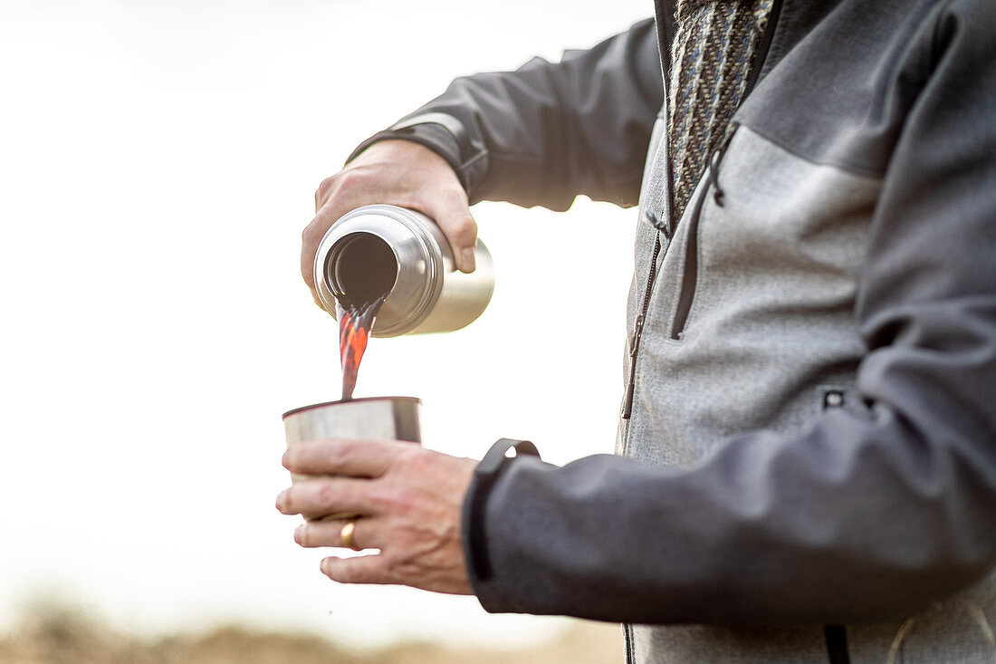 Großbritannien, London, Epping Forest, Nahaufnahme Mann gießt Kaffee aus Thermoskanne