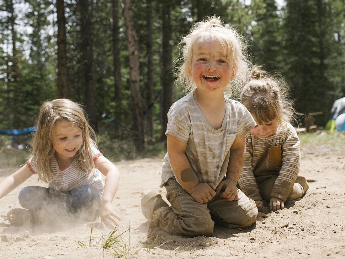 Drei lächelnde Mädchen (2-3,4-5 Jahre) spielen im Sand auf dem Campingplatz, Wasatch-Cache National Forest