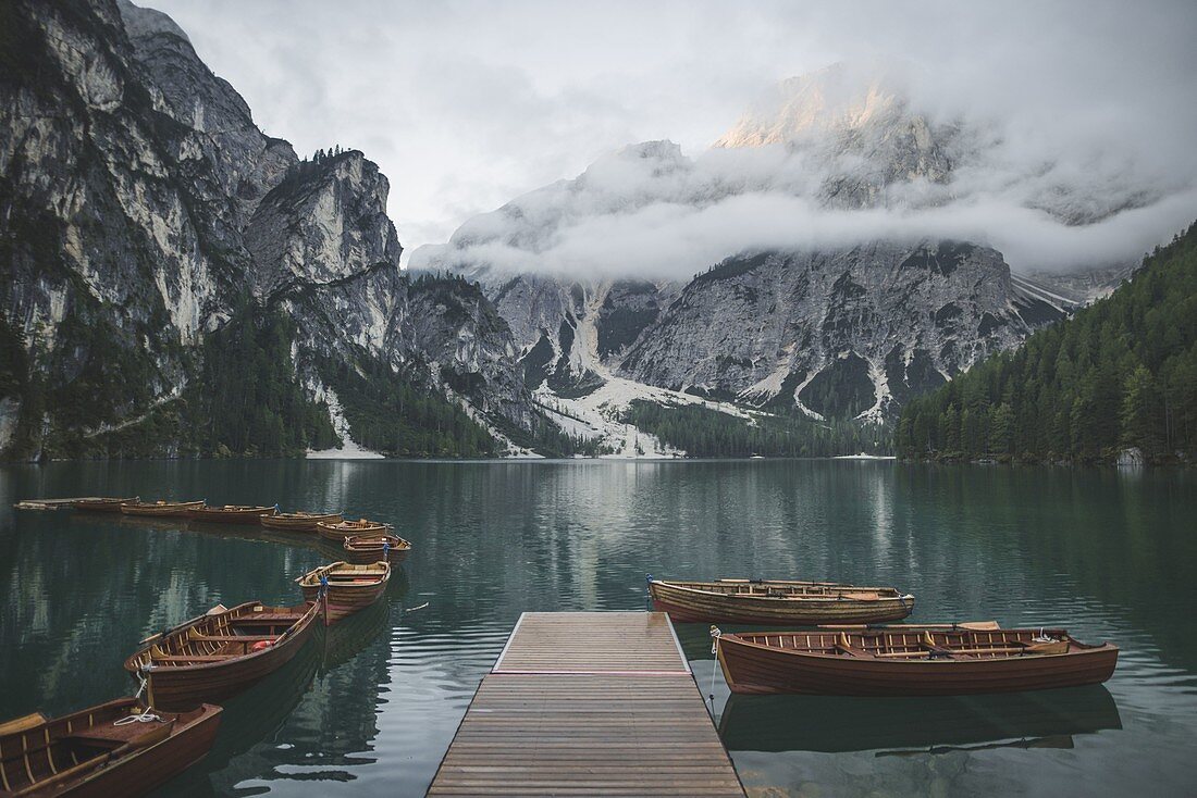 Italien, Pragser Wildsee, Dolomiten, Südtirol, Ruderboote vor Anker in der Nähe von Steg im Bergsee