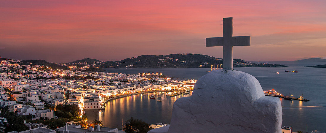 Griechenland, Kykladen, Mykonos, Chora, Kreuz auf Kirche mit Küstendorf im Hintergrund