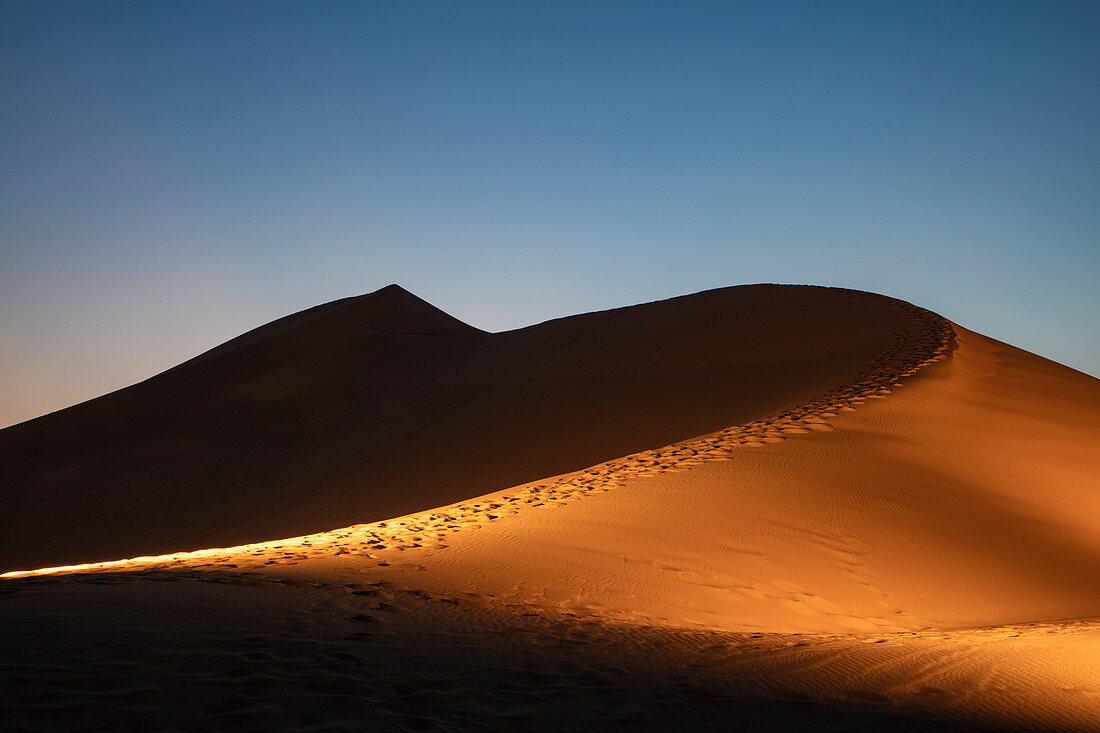 Beleuchtete Sanddüne außerhalb Arabian Nights Village Wüstenresort in der Abenddämmerung, Arabian Nights Village, Razeen Area von Al Khatim, Abu Dhabi, Vereinigte Arabische Emirate, Emirate, Naher Osten