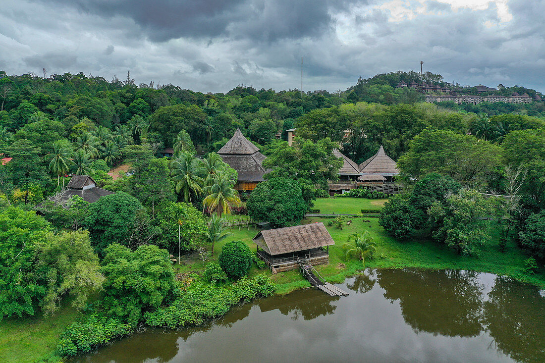 Aerial view of lake, huts and jungle in the Sarawak Cultural Village, Kampung Budaya Sarawak, near Kuching, Sarawak, Borneo, Malaysia, Asia,