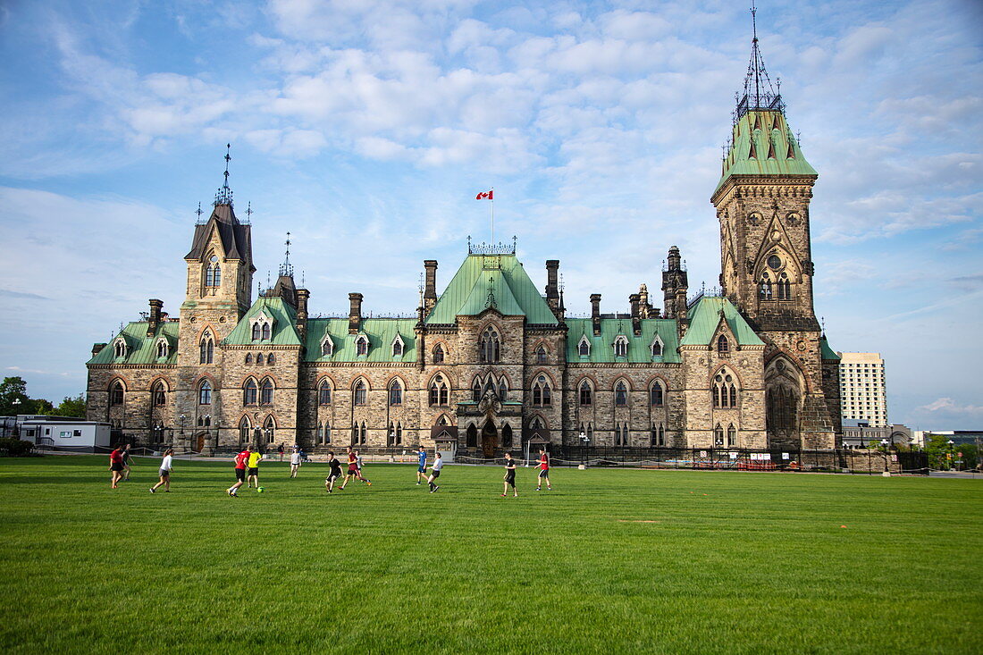 Menschen spielen Fußball auf dem Rasen vor dem Parlamentsgebäude, Ottawa, Ontario, Kanada, Nordamerika
