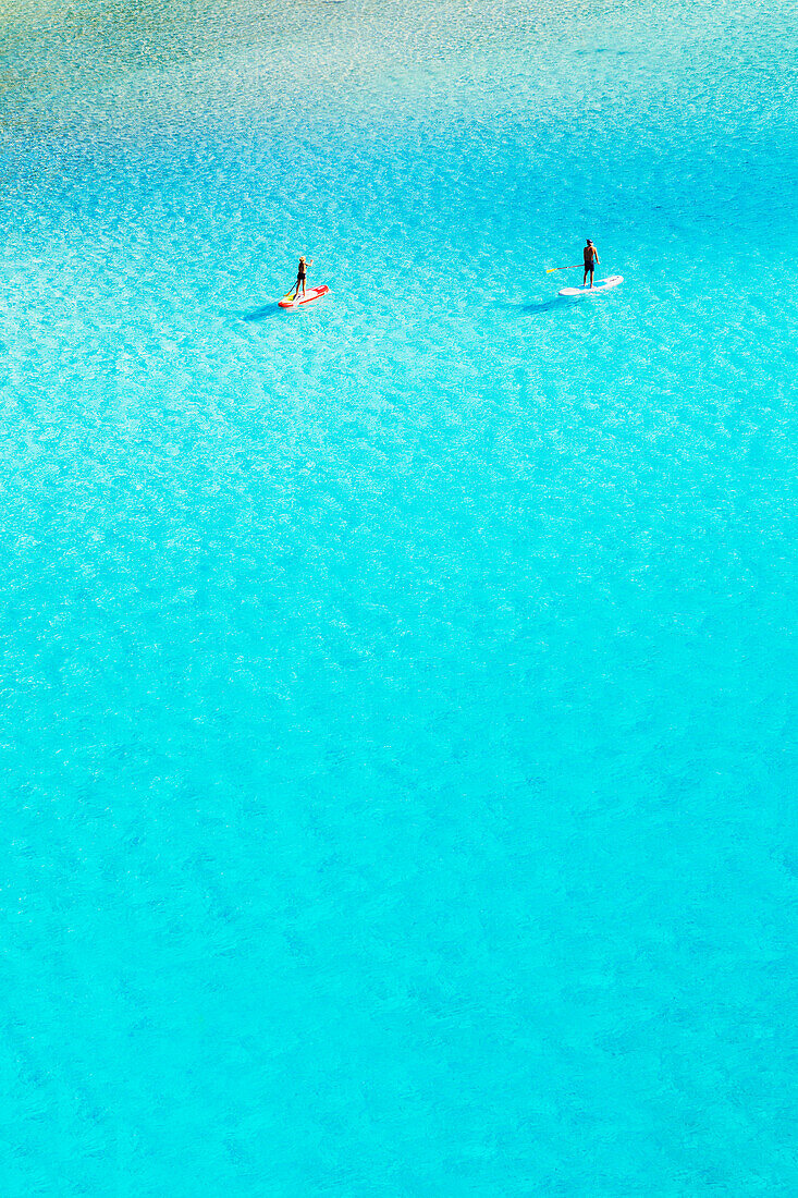 Leute paddeln in Cala Mitjana, SUP, Menorca, Balearen. Spanien
