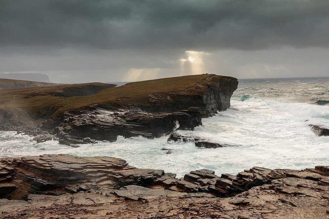 Sturm, Brandungsbrecher, Steilküste von Yesnaby, Sonnenstrahl durch Wolken, Klippen, Orkney, Schottland UK 